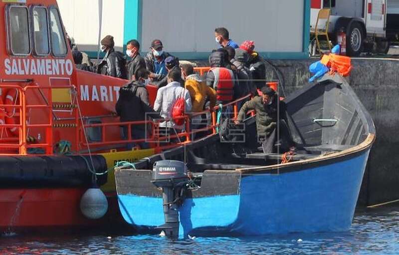 Uno de los inmigrantes rescatados días atrás recoge de la patera su mochila antes de desembarcar en Arguineguín (Foto EFE / Elvira Urquijo A.)